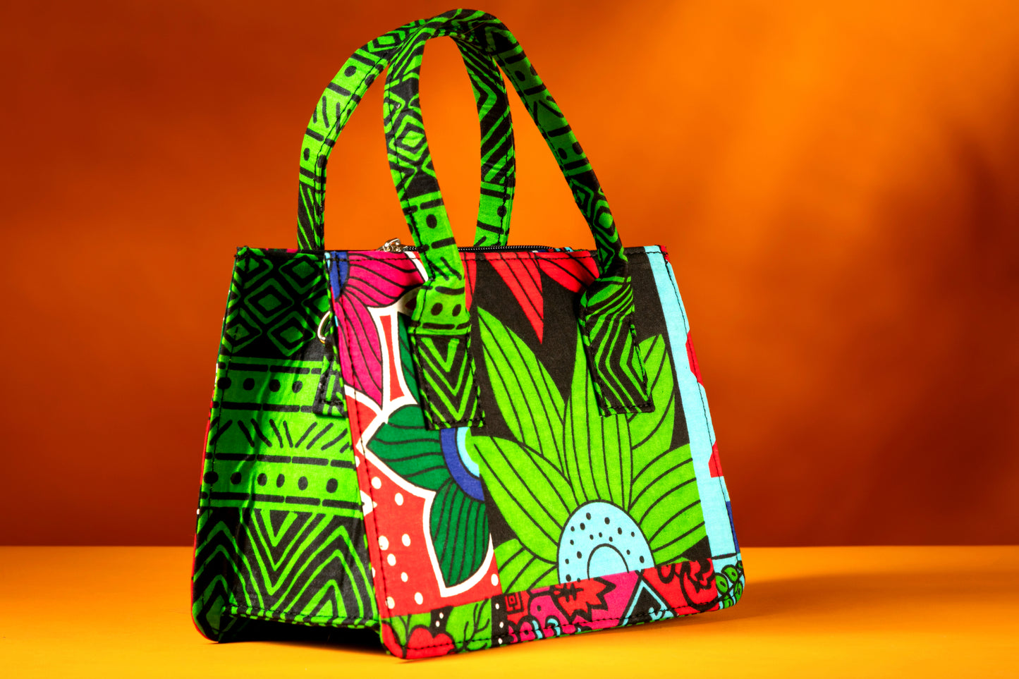 Side angle of the Balangi Bag highlighting the vibrant contrast between the front, side and the handle, handmade with African wax cotton.