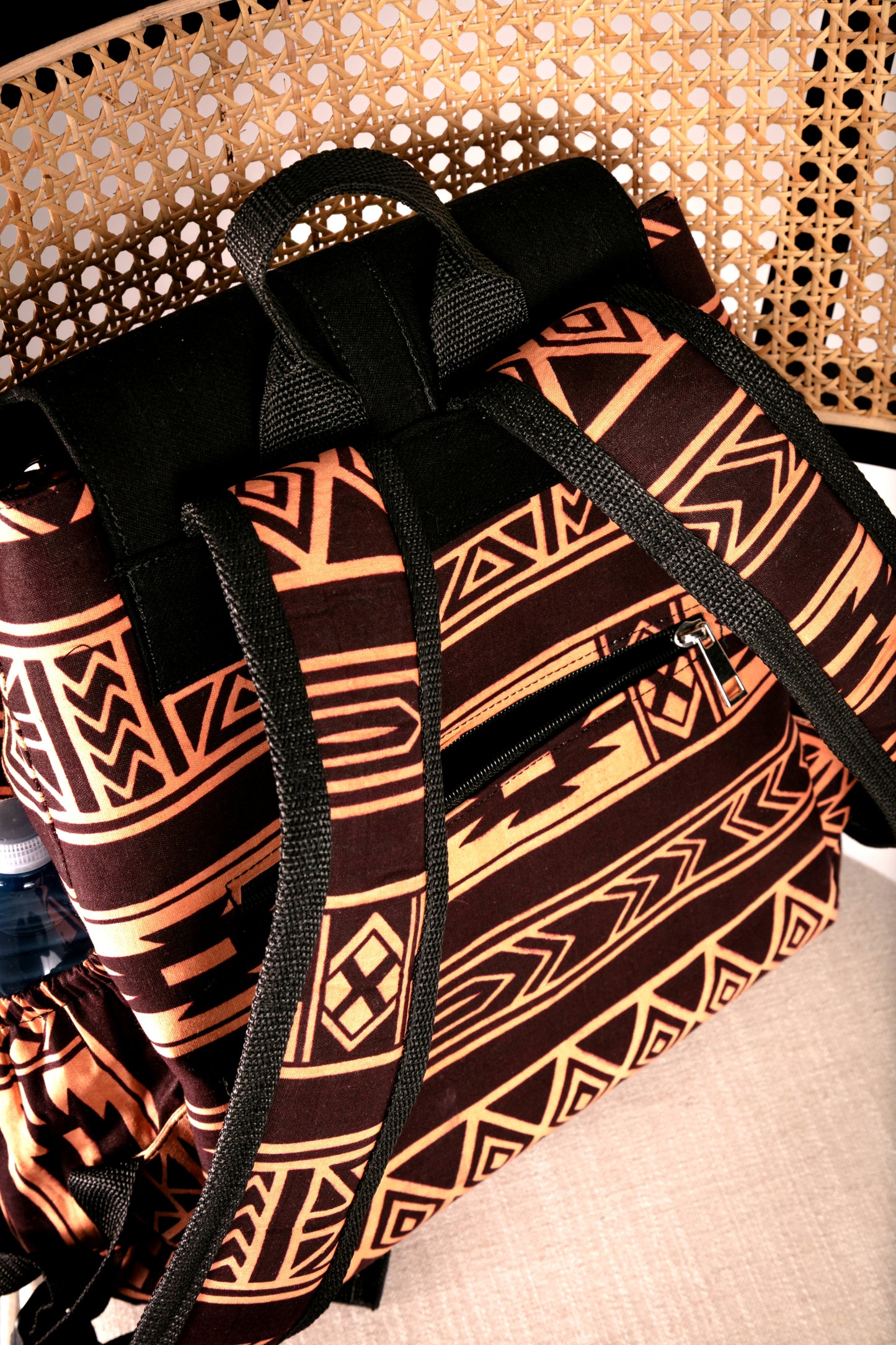 Back view of backpack with brown and nude tribal pattern on a chair