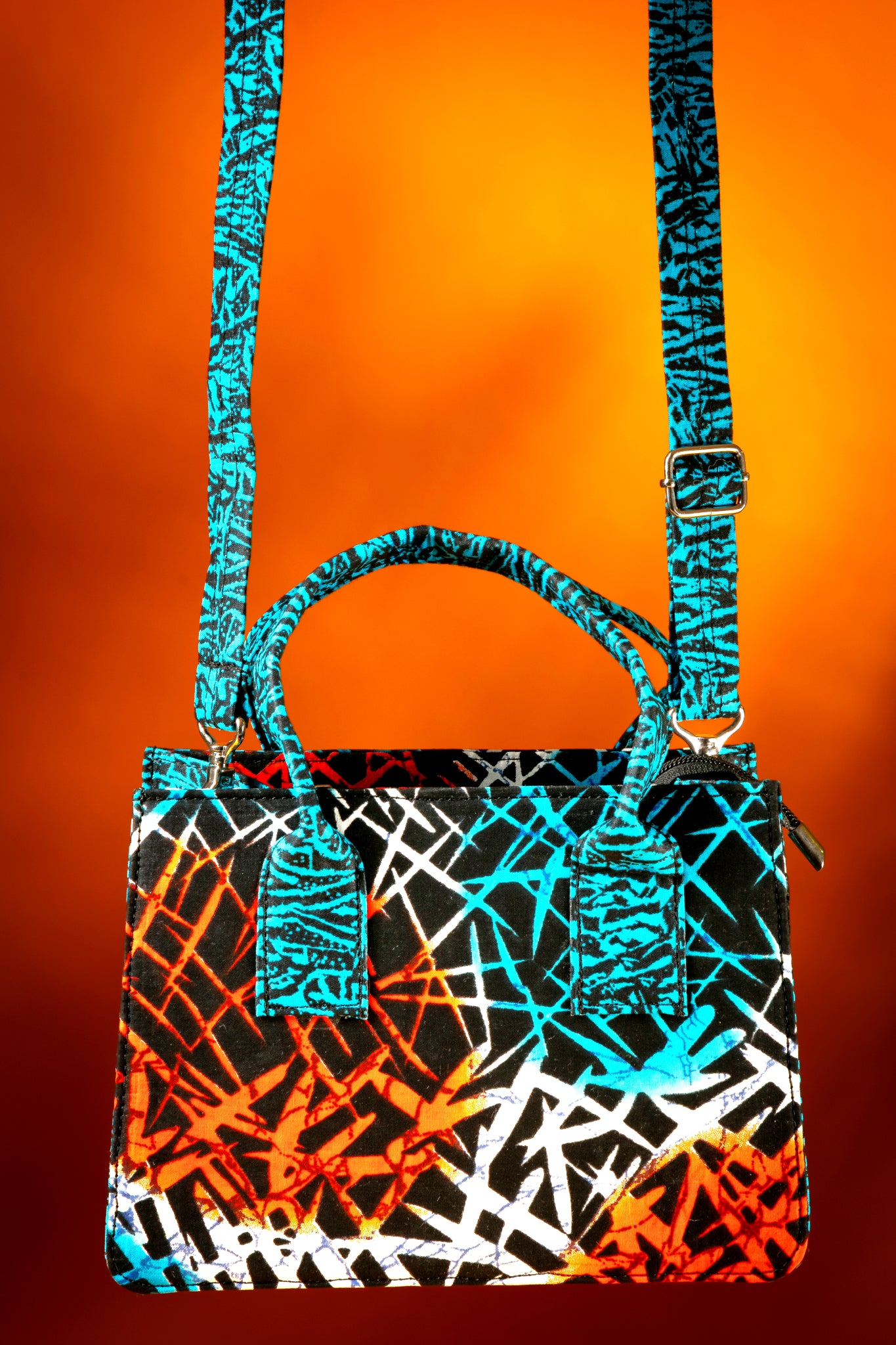 Front view of the Gyil Bag with the strap attached, highlighting the vibrant contrast between the body and the strap, handmade with African wax cotton.