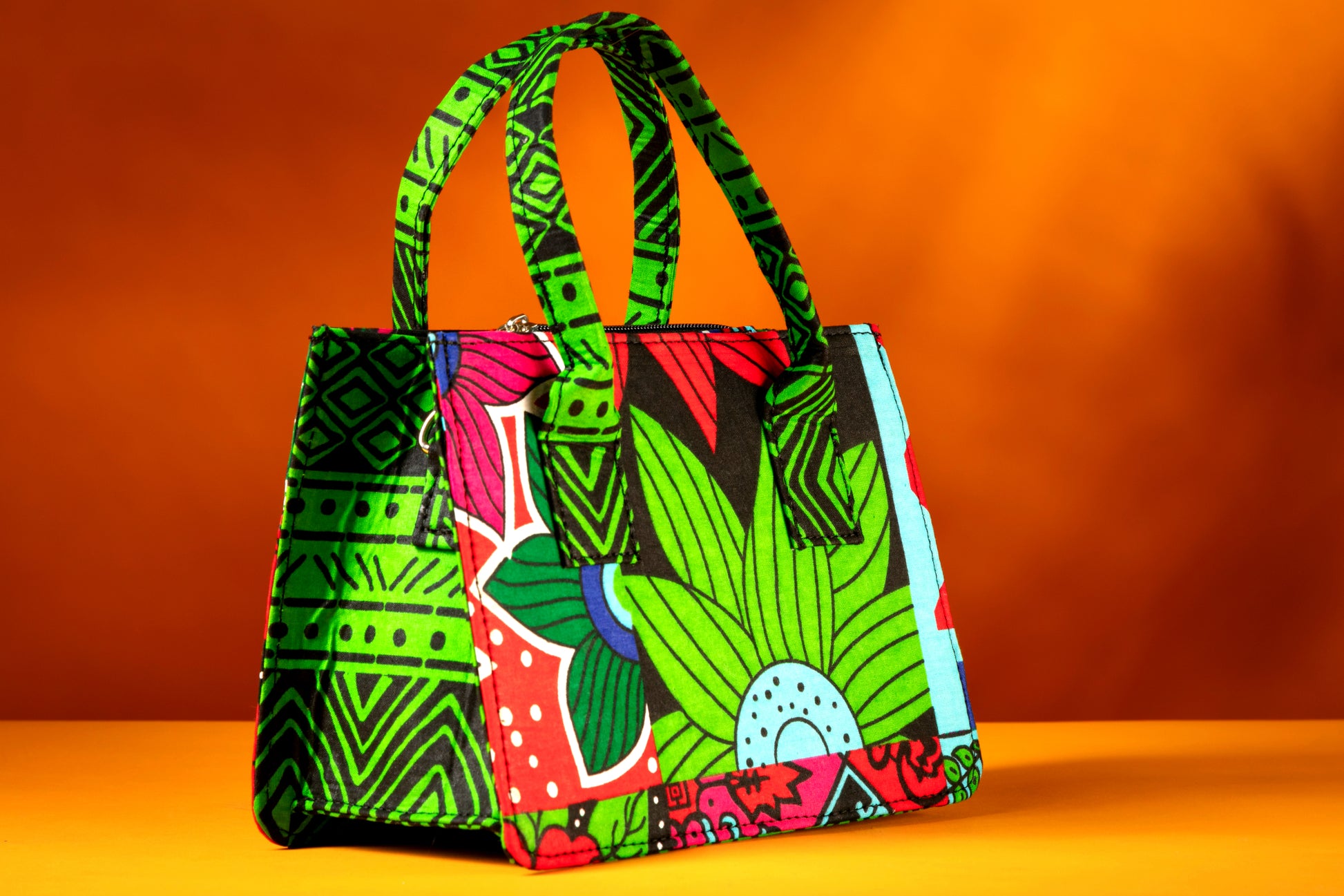 Side angle of the Balangi Bag highlighting the vibrant contrast between the front, side and the handle, handmade with African wax cotton.