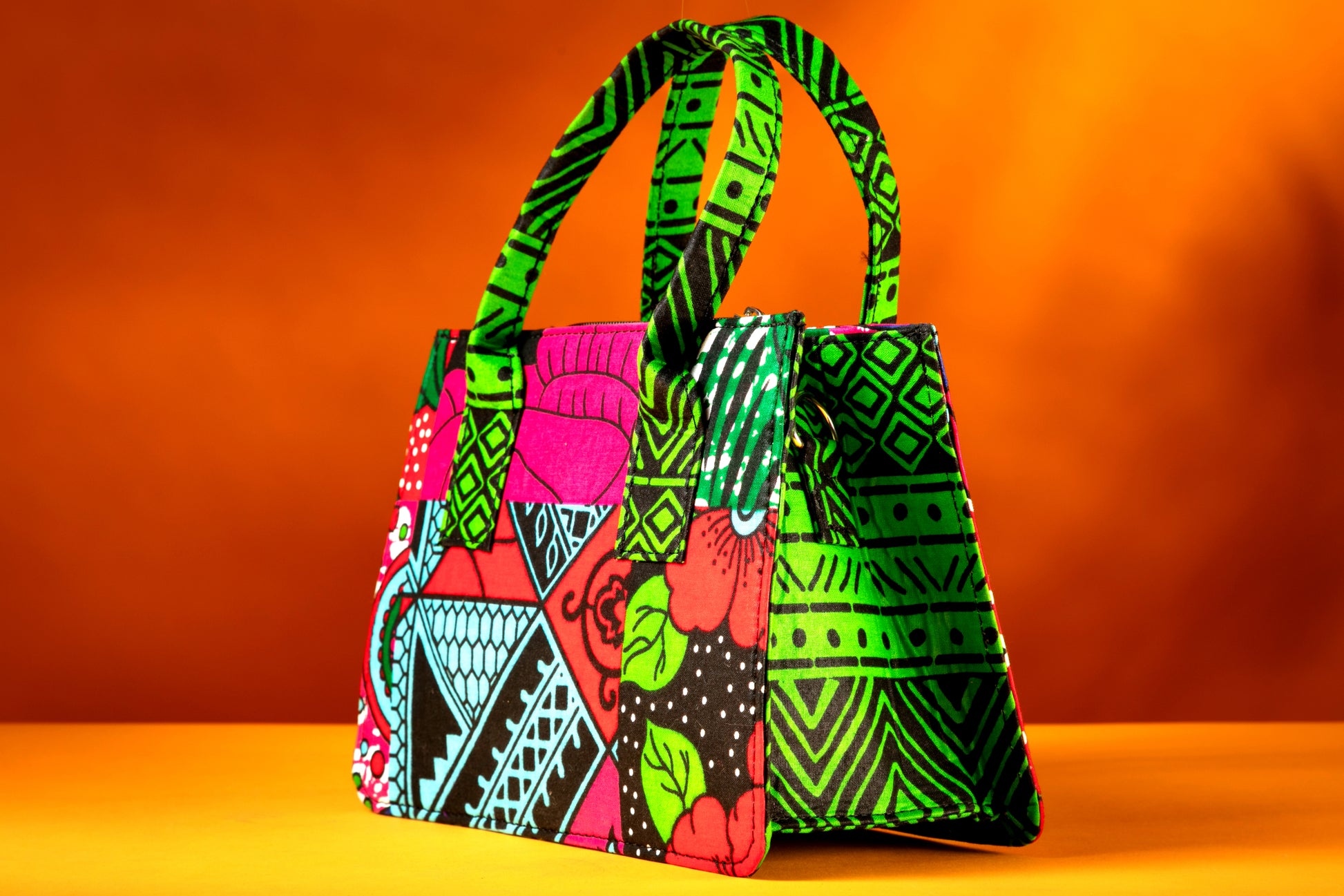 Side angle of the Balangi Bag highlighting the vibrant contrast between the front, side and the handle, handmade with African wax cotton.