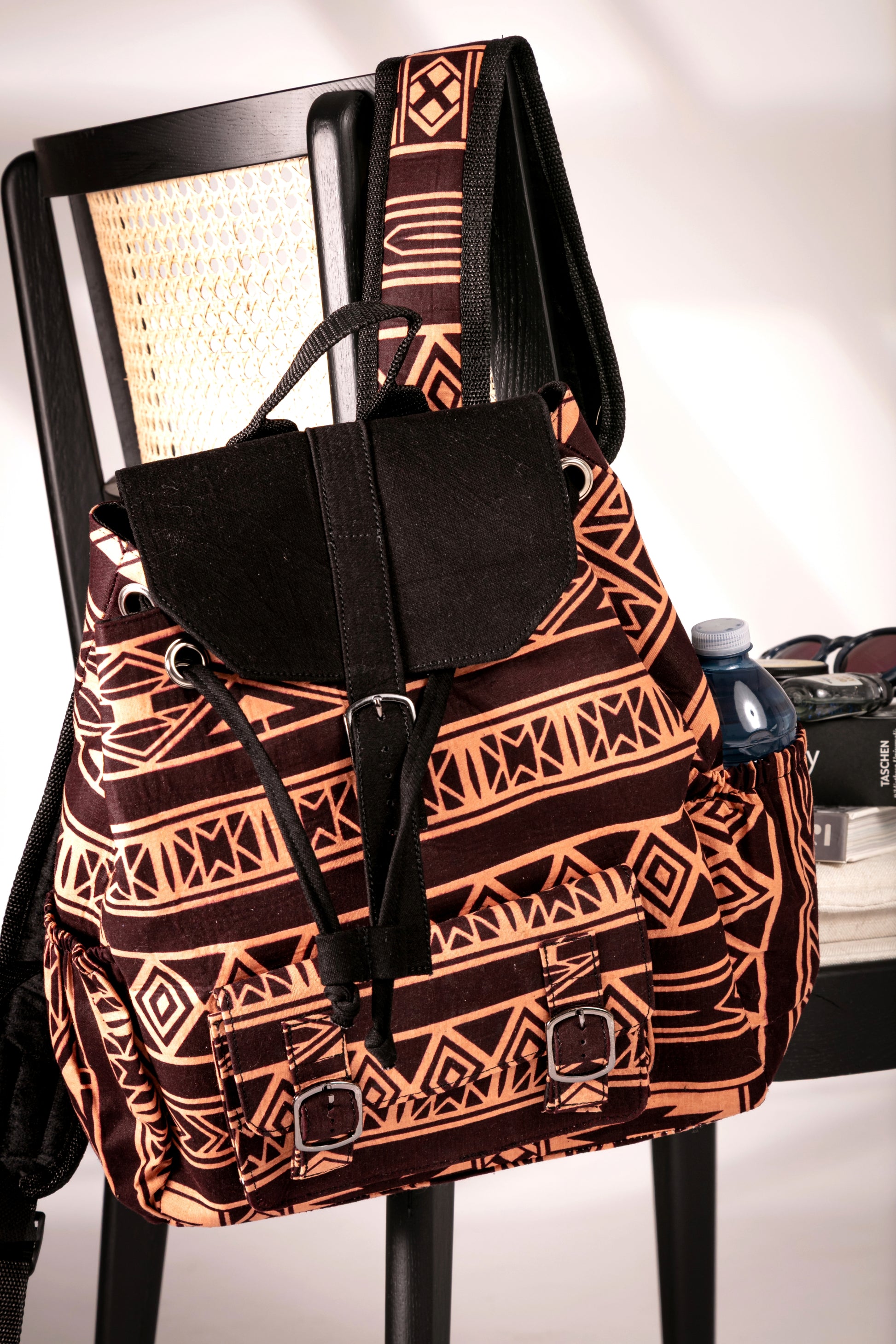 Front view of backpack with brown and nude tribal pattern hanging on a chair