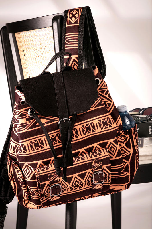 Front view of backpack with brown and nude tribal pattern hanging on a chair