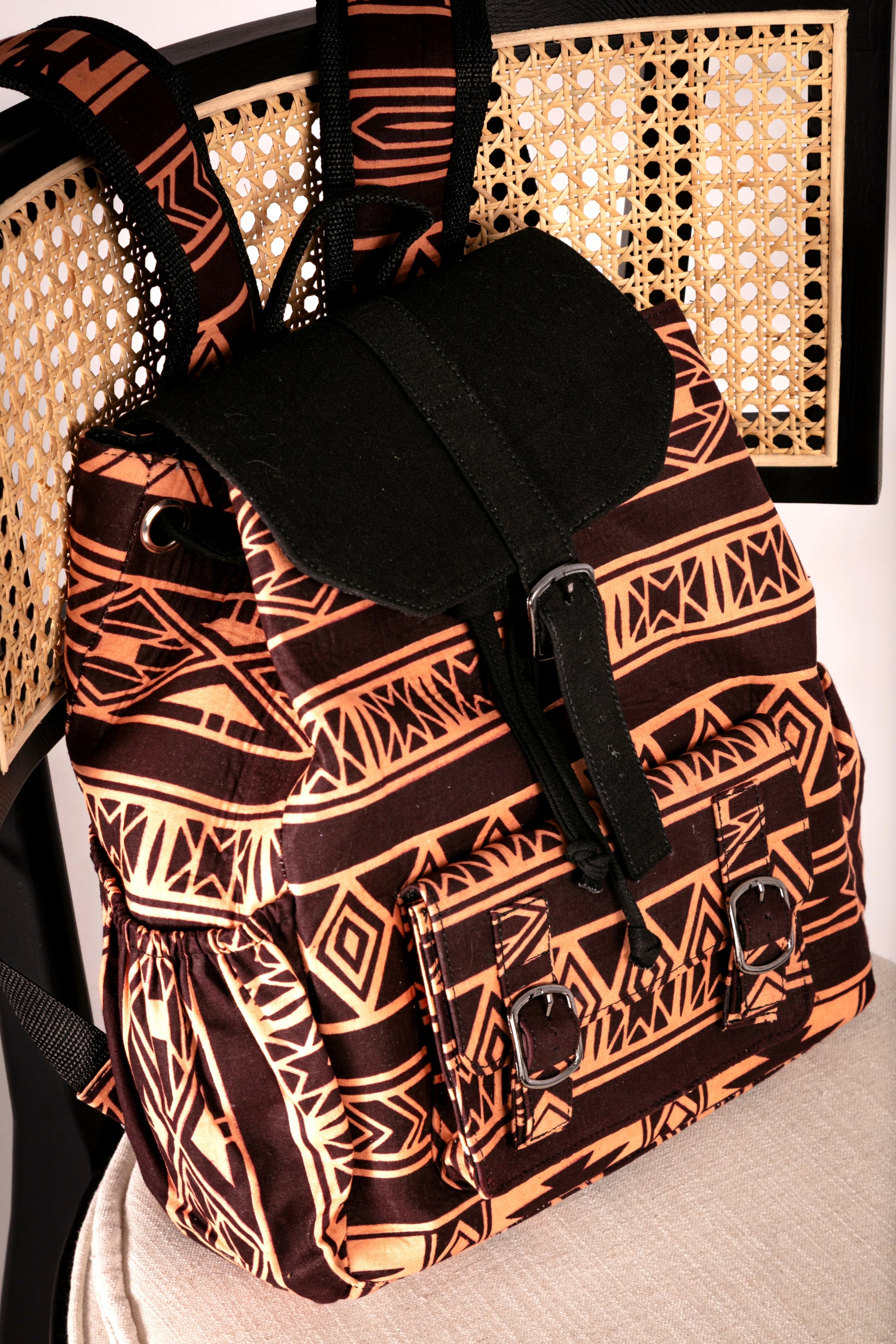 Angled view of backpack with brown and nude tribal pattern on a chair