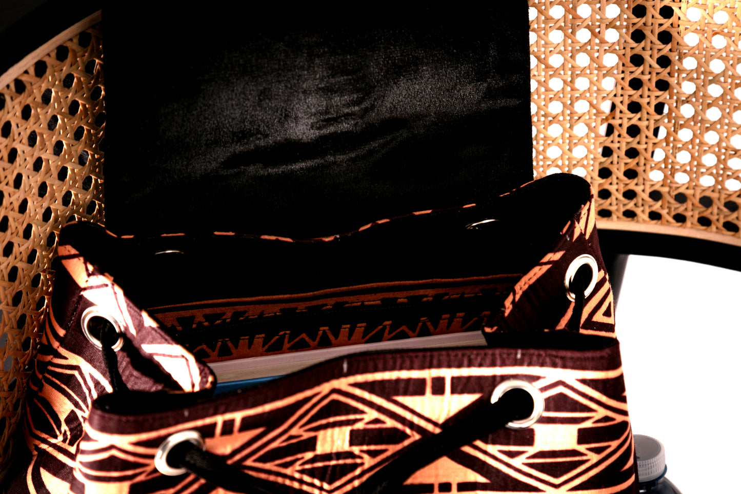 Inside of backpack with brown and nude tribal pattern on a chair
