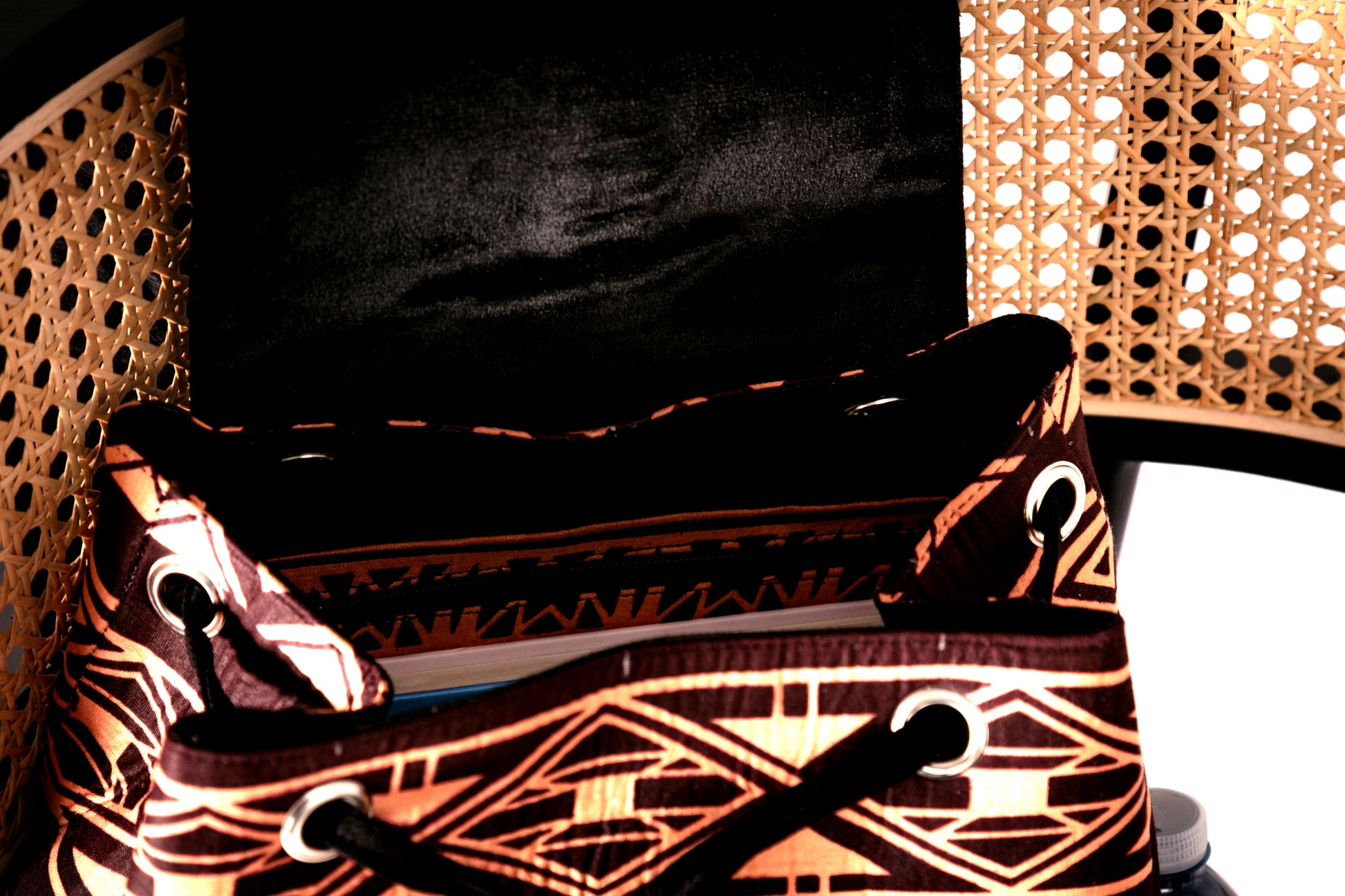 Inside of backpack with brown and nude tribal pattern on a chair