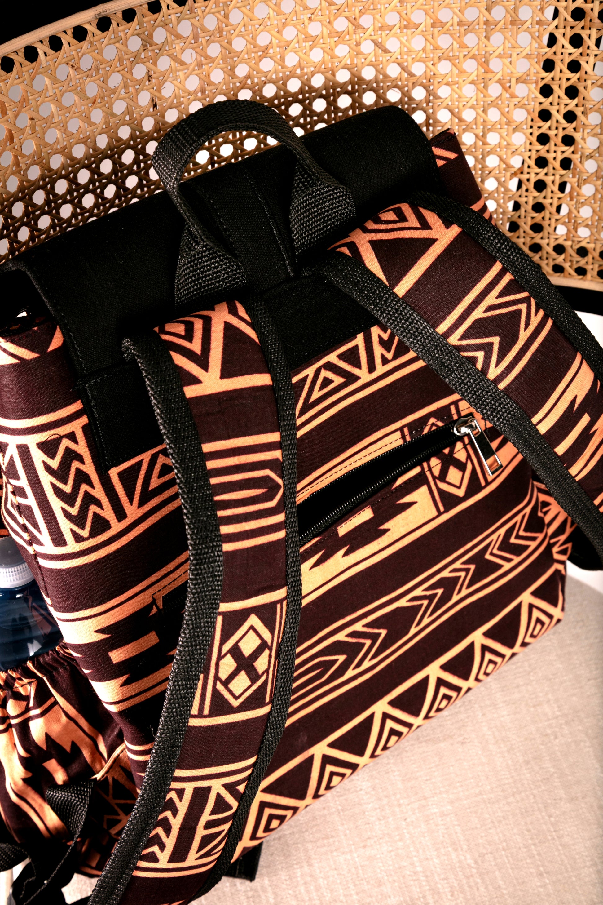 Back view of backpack with brown and nude tribal pattern on a chair
