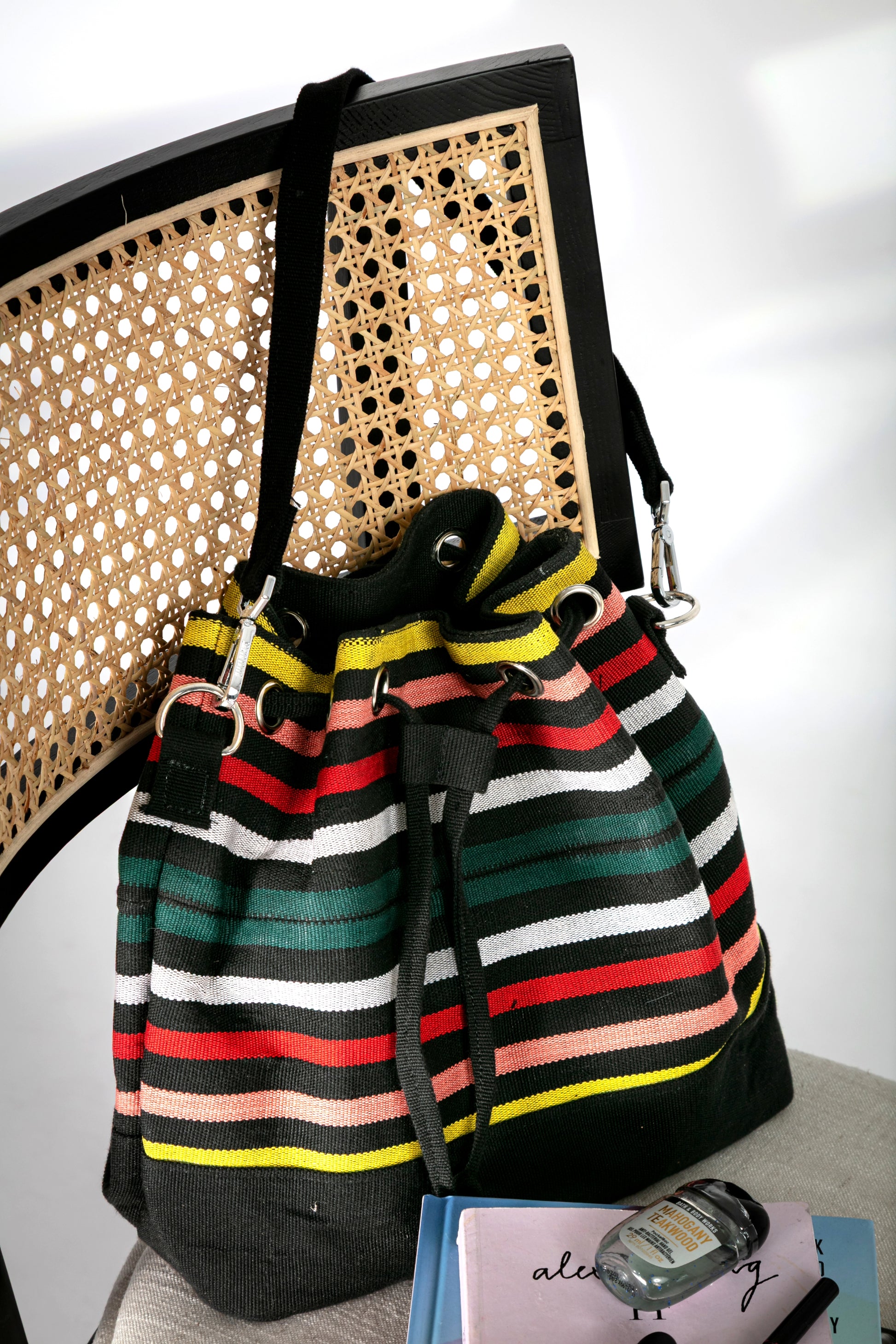 Multicolor striped bucket bag with short strap and a drawstring closure on a chair