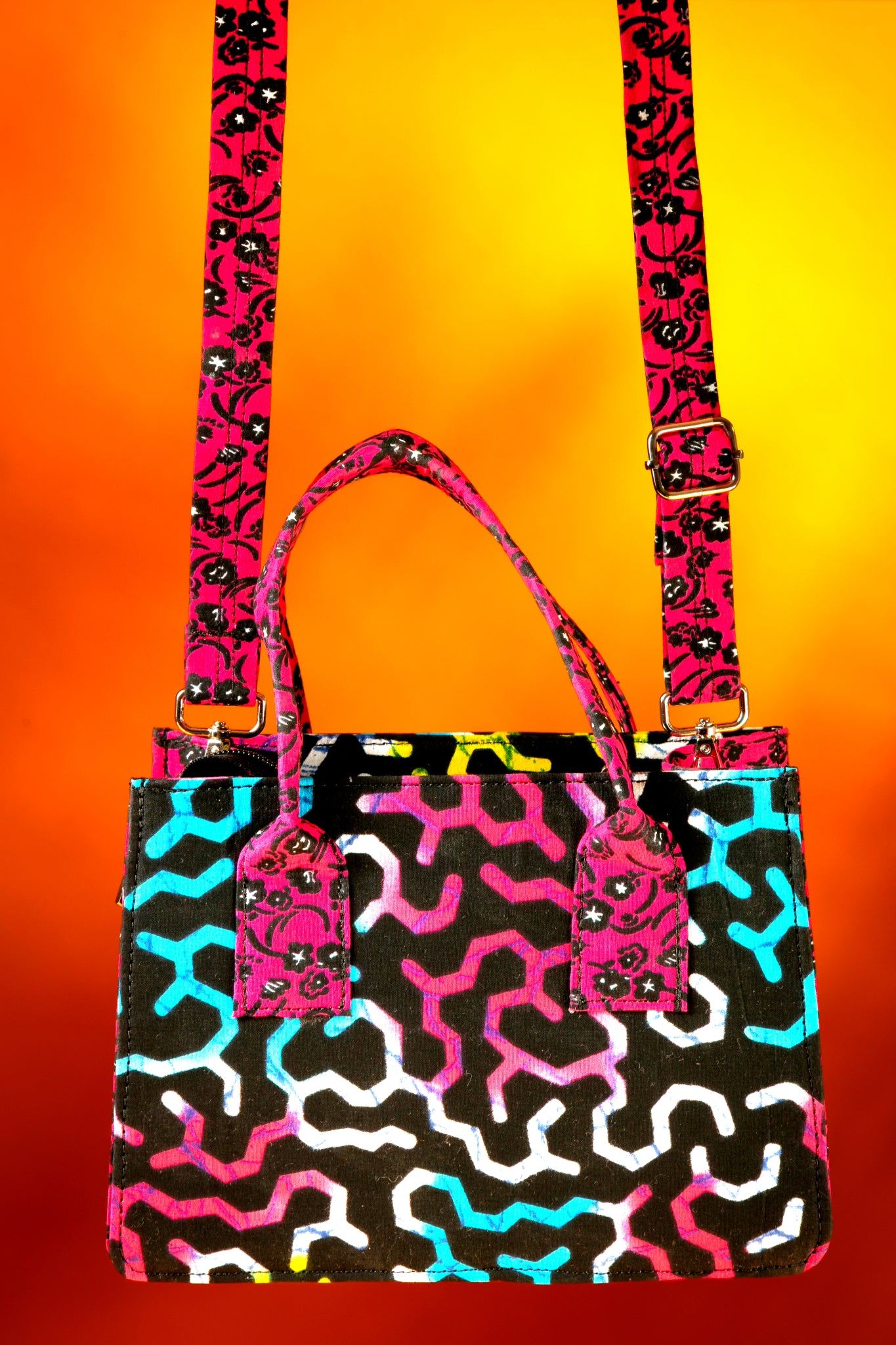 Front view of the Ncegele Bag with the strap attached, highlighting the vibrant  contrast between the body and the strap, handmade with African wax cotton.