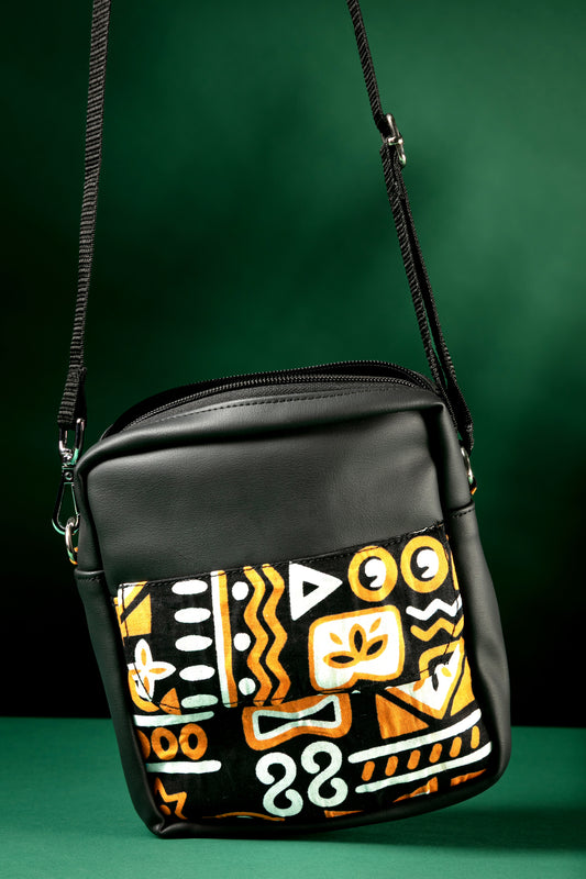 Black crossbody bag with brown, black & white tribal patterns on a green background